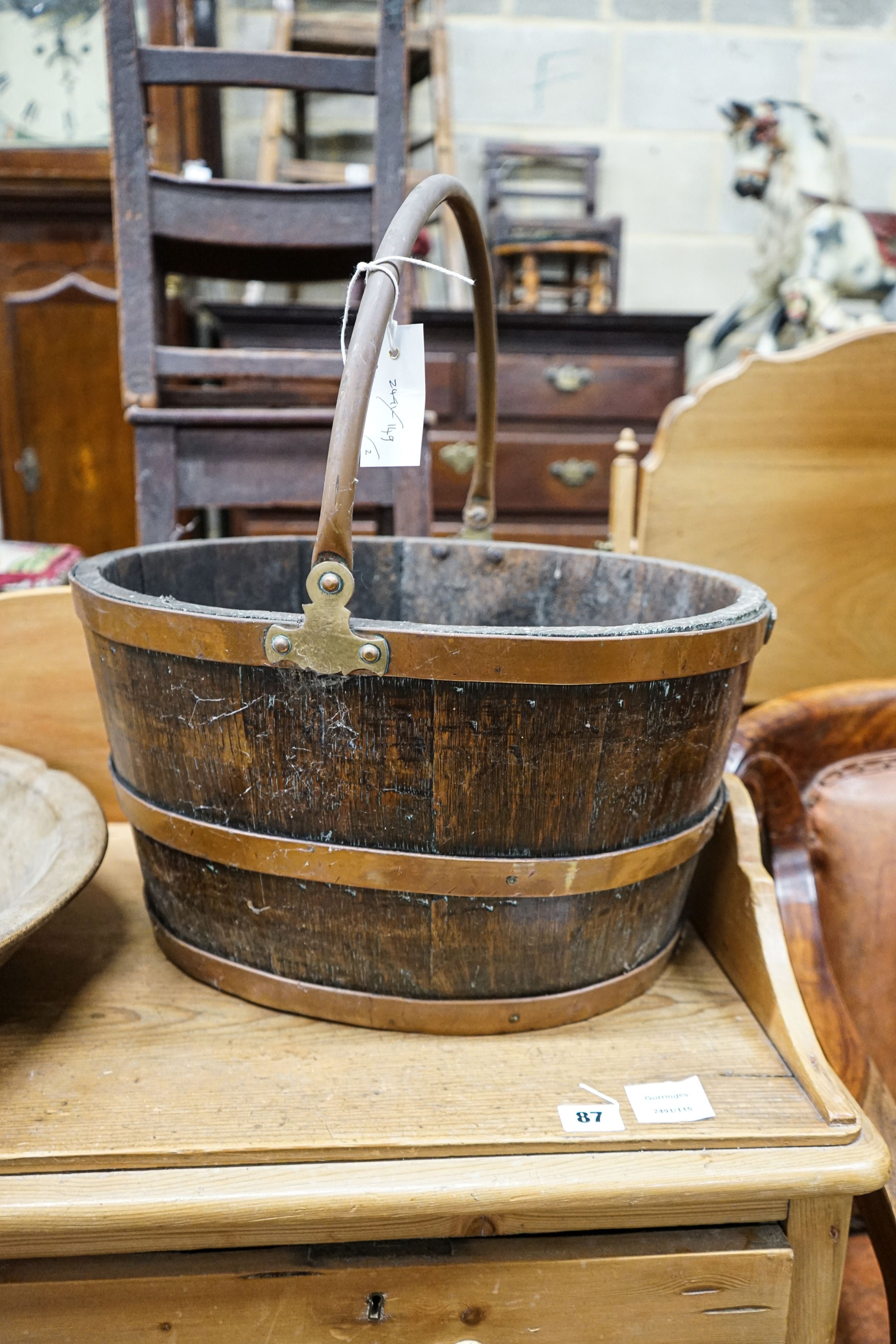 A copper bound staved oak log basket, width 45cm, depth 36cm, together with a circular turned beech bowl, 51cm